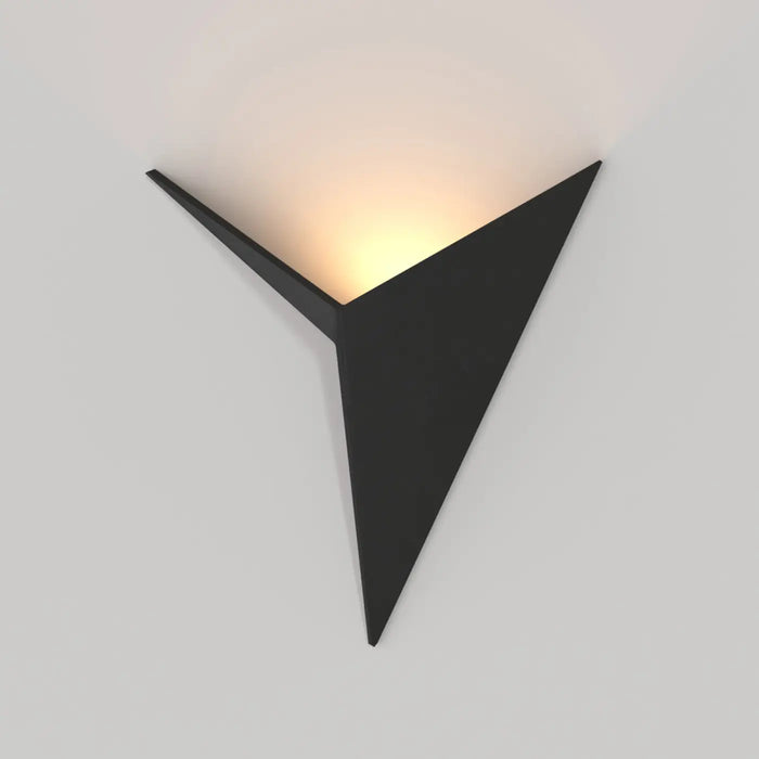 Applique murale origami en acier noir sculptant la lumière au mur