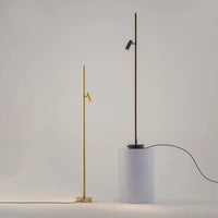 Lampadaire LED ultra-fin doré éclairant un angle de chambre