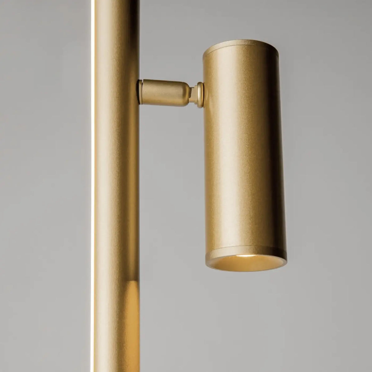 Lampadaire LED ultra-fin doré dans une entrée minimaliste