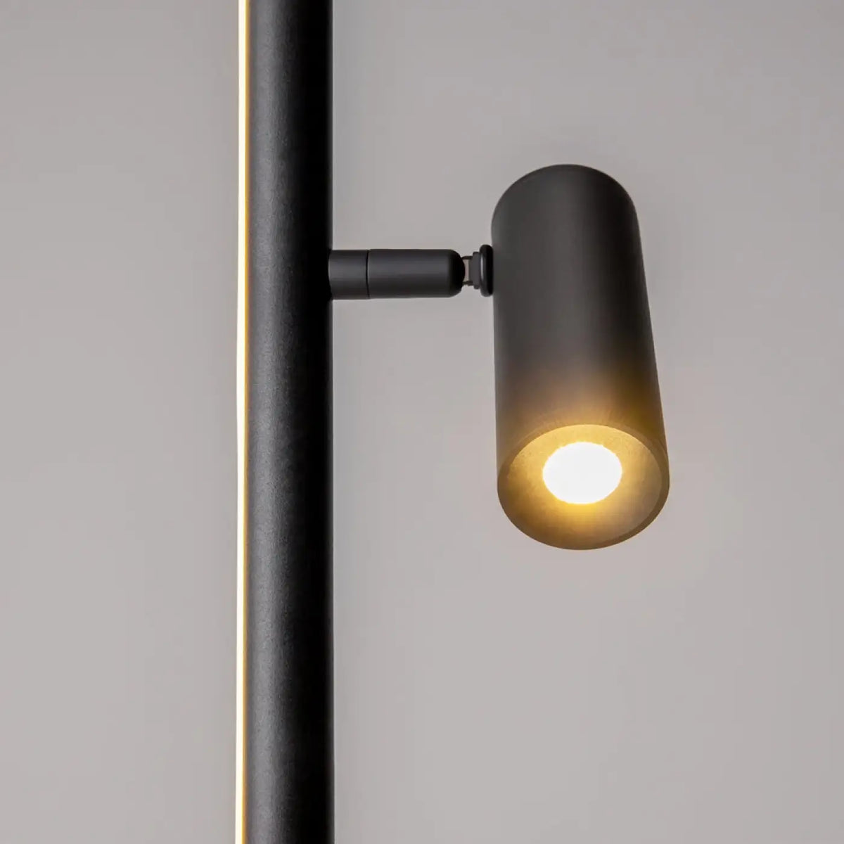 Lampadaire LED ultra-fin noir illuminant un bureau contemporain