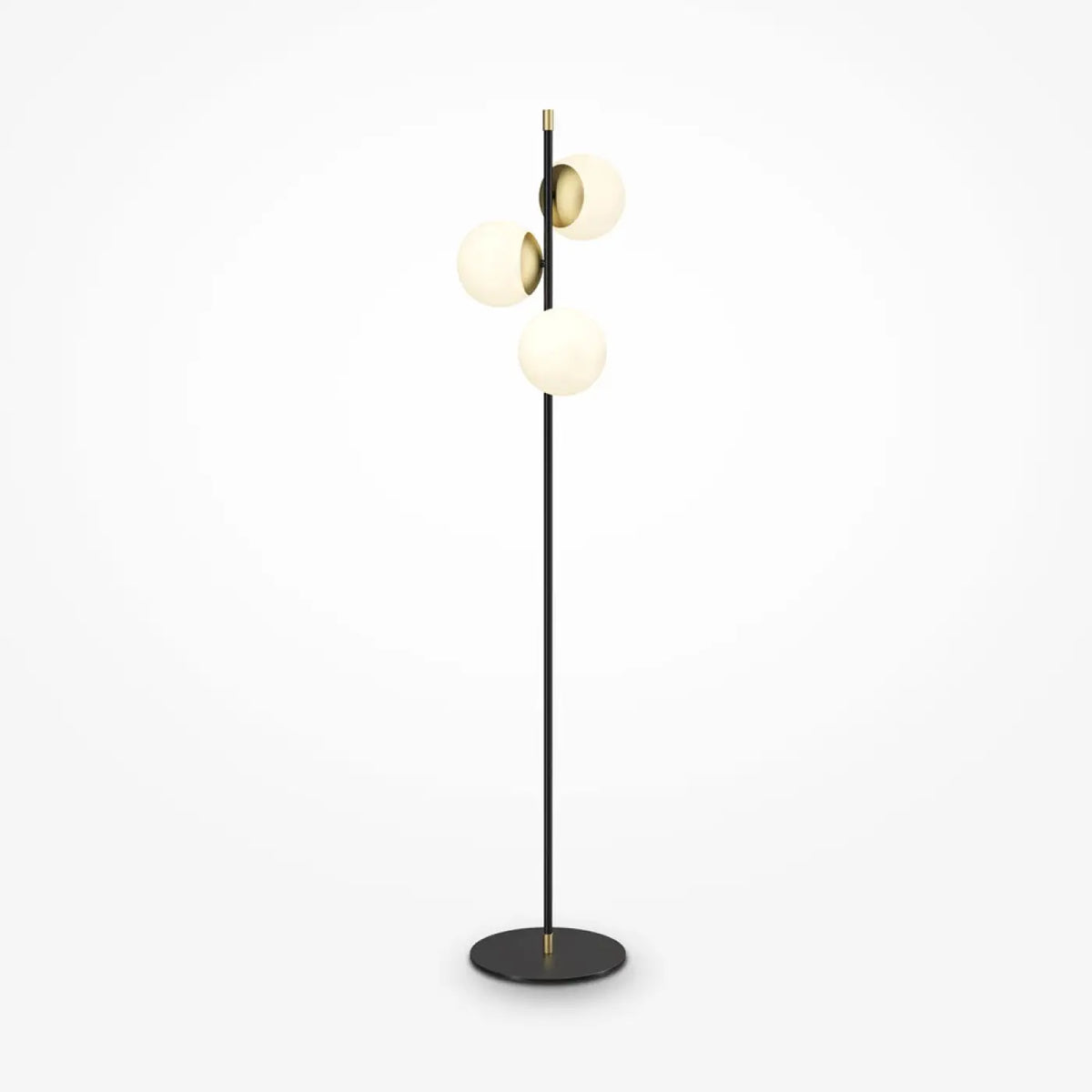 Lampadaire trois globes opalins placé près d'un canapé moderne