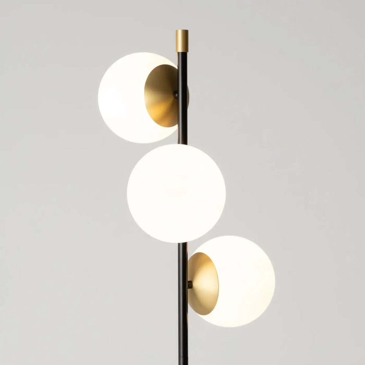 Lampadaire trois globes opalins installé dans un salon élégant