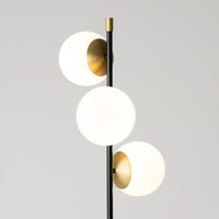 Lampadaire trois globes opalins installé dans un salon élégant