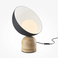 Lampe de chevet en pierre Maël posée sur une table de nuit en bois