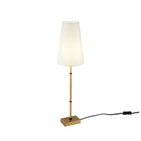 Lampe de chevet dorée posée sur une table de nuit cosy