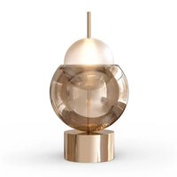 Lampe de chevet en verre Théa argentée posée sur une table de nuit