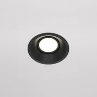 Spot encastrable rond blanc diffusant une lumière douce en chambre
