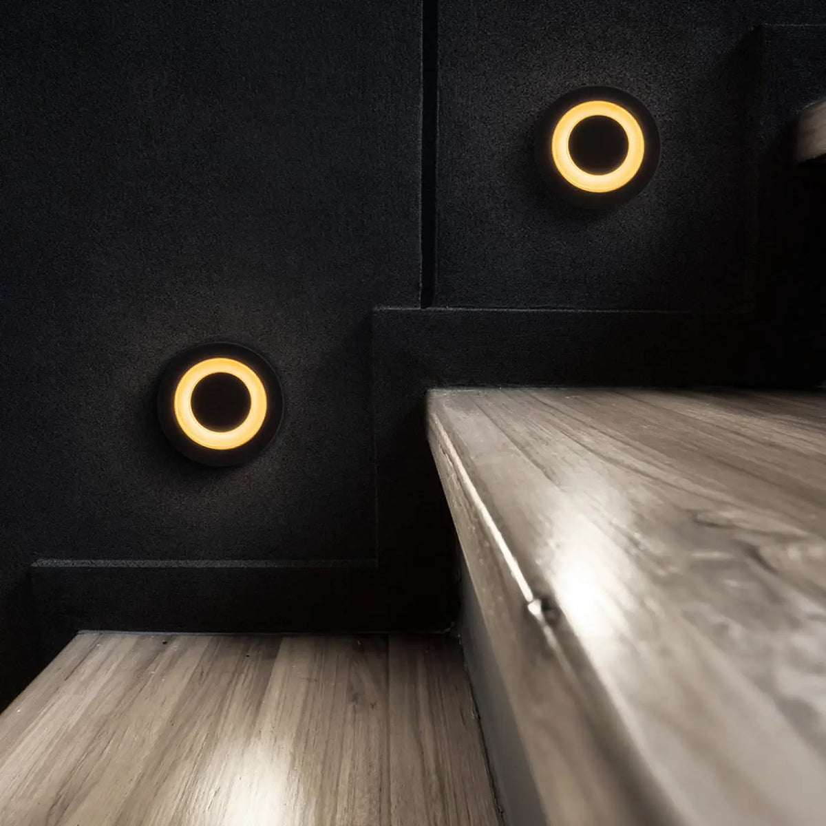 Spot encastré étanche noir installé dans un escalier intérieur