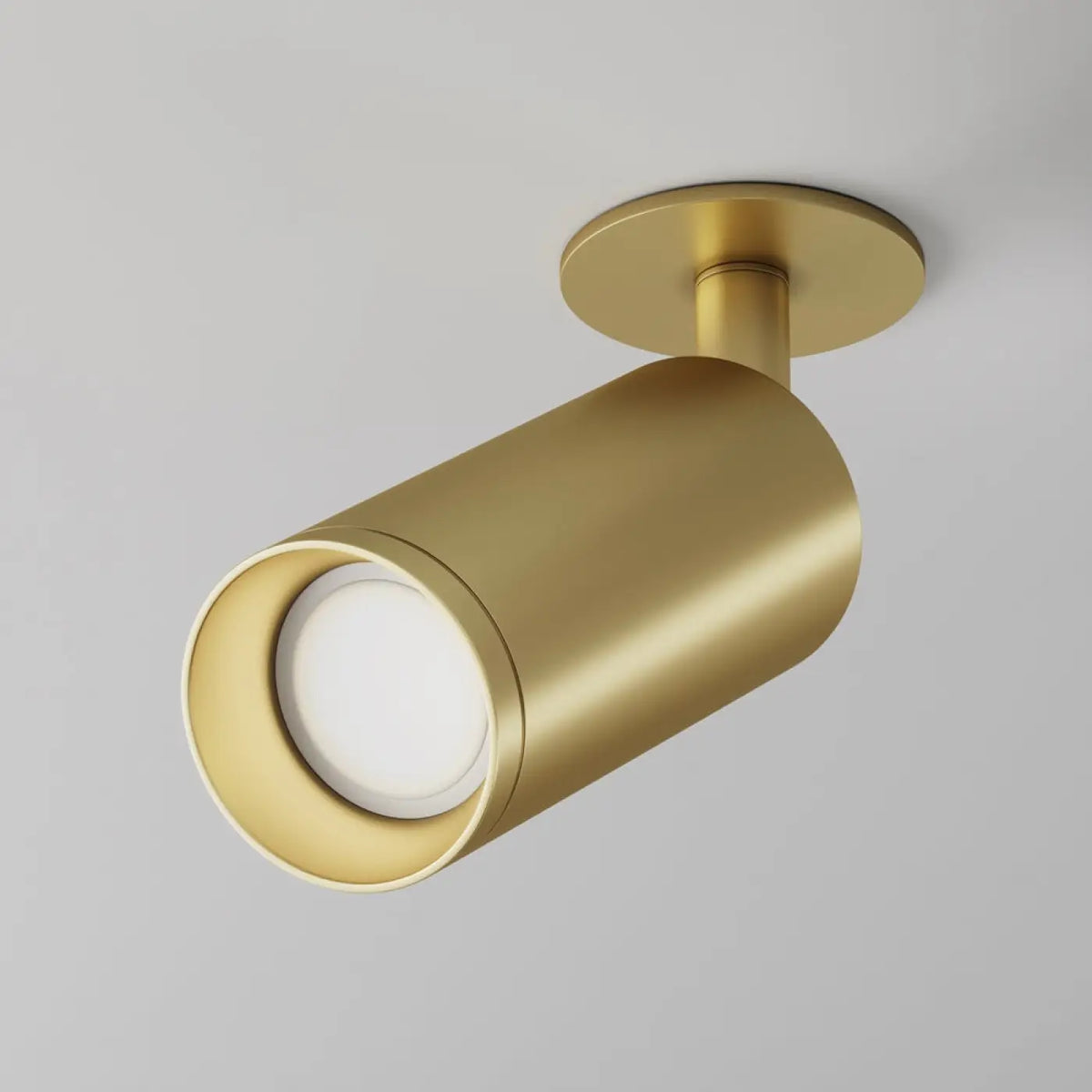 Spot orientable doré illuminant un couloir avec précision.