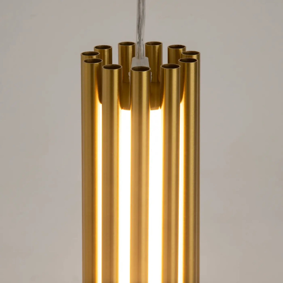 Détail de la suspension cylindrique dorée et son diffuseur en verre