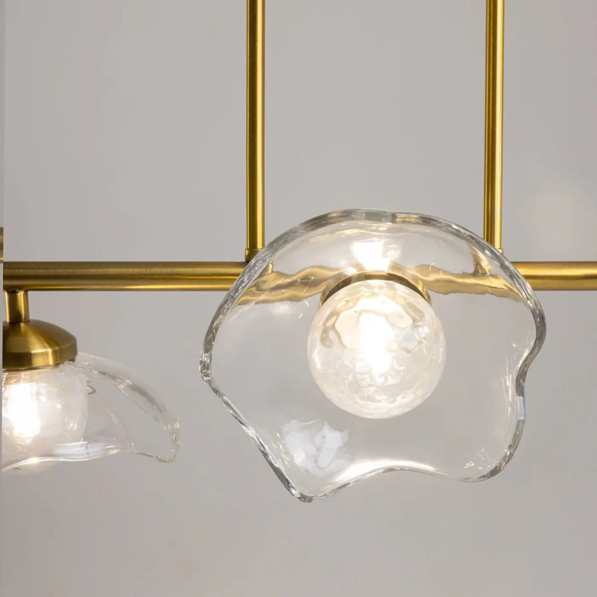 Éclairage chaleureux d'une suspension linéaire dorée au style Art déco