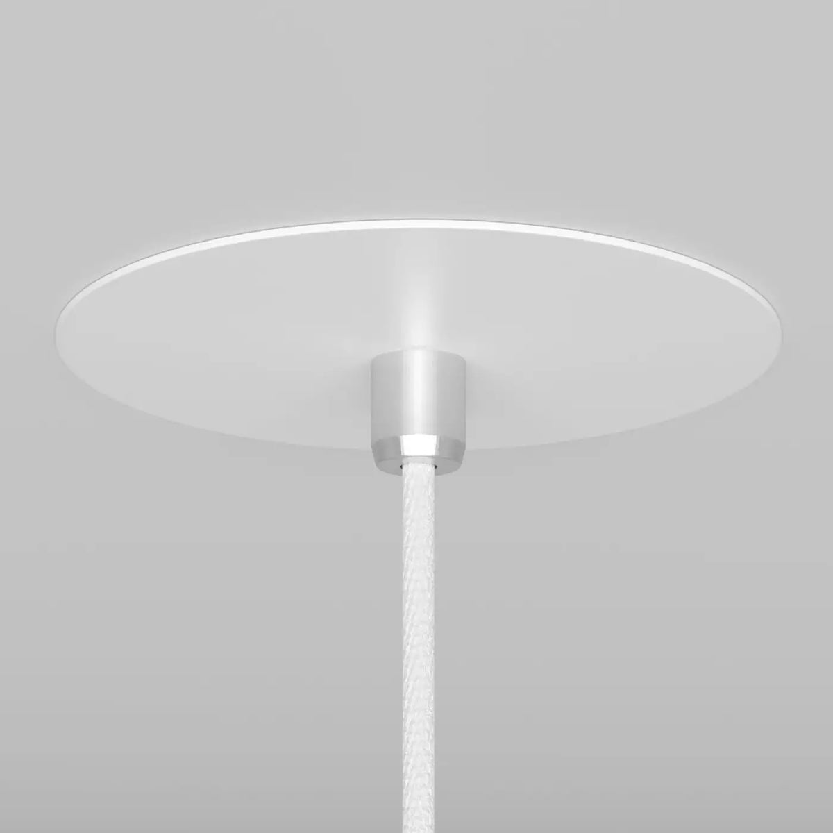 Suspension cône noire installée près d'une table de chevet
