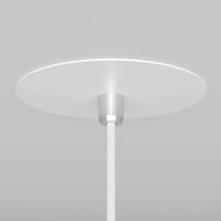 Suspension cône noire installée près d'une table de chevet