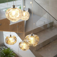 Suspension en verre organique Talia finition Crystal au-dessus d'une table