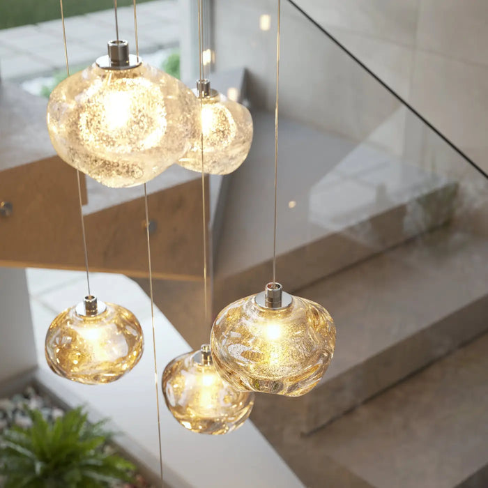 Suspension en verre organique Talia finition Crystal au-dessus d'une table