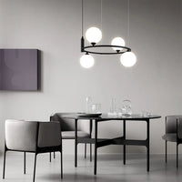 Suspension à globes en verre et cercle doré au-dessus d'une table