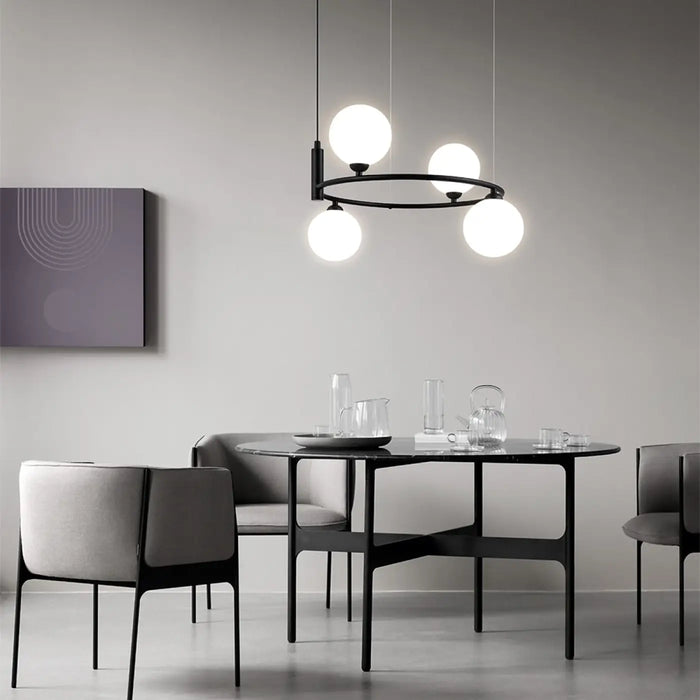 Suspension à globes en verre et cercle doré au-dessus d'une table