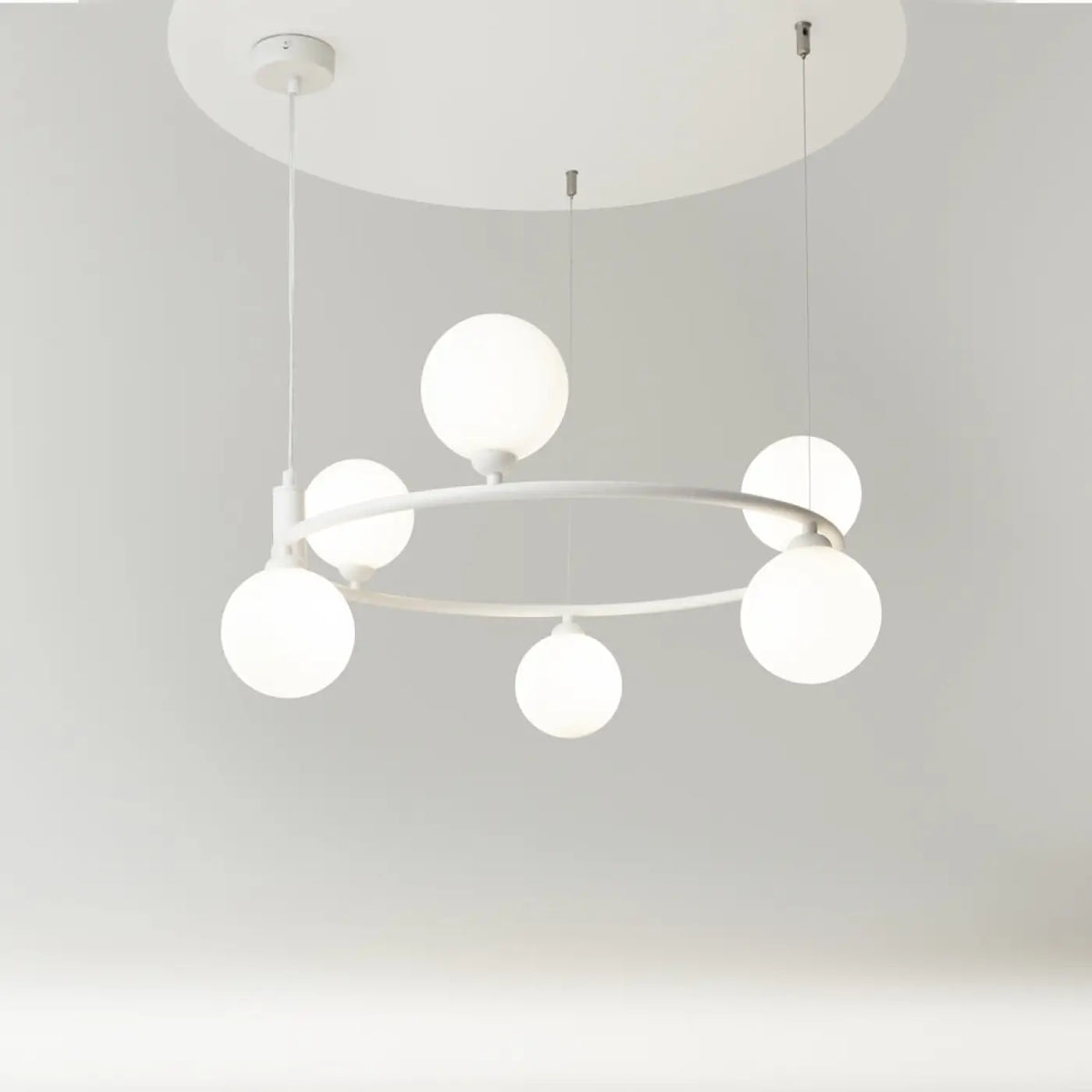 Suspension à globes en verre et cercle doré au-dessus d'une table, vue 19